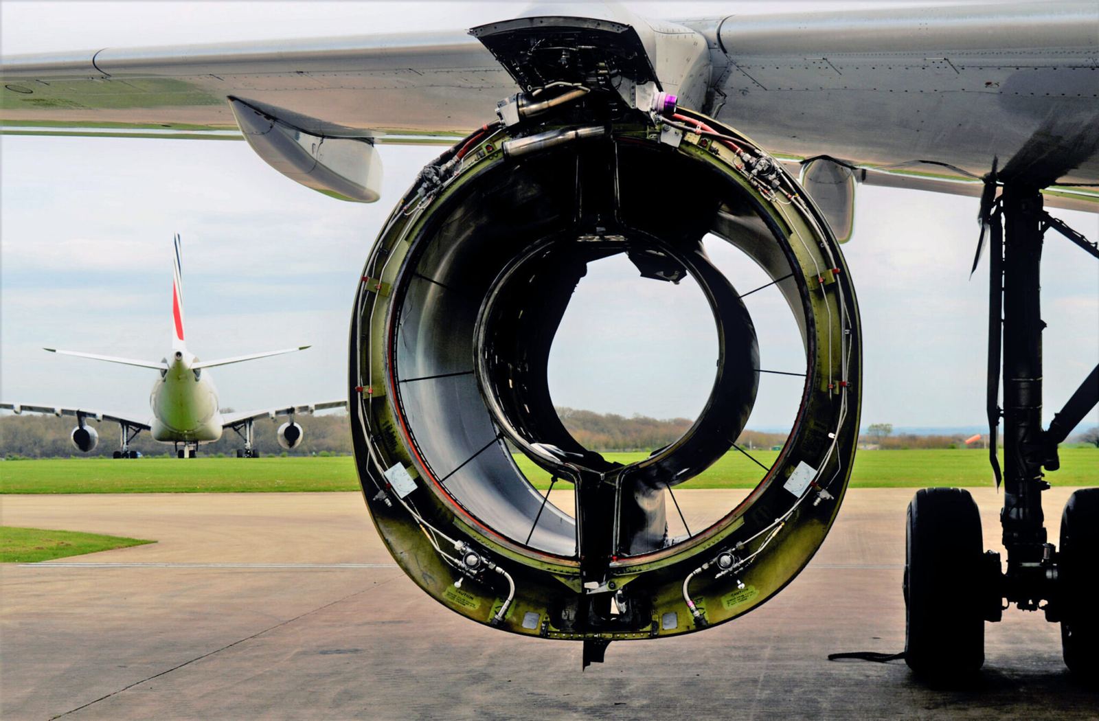 Aircraft undergoing disassembly with harvested components staged nearby